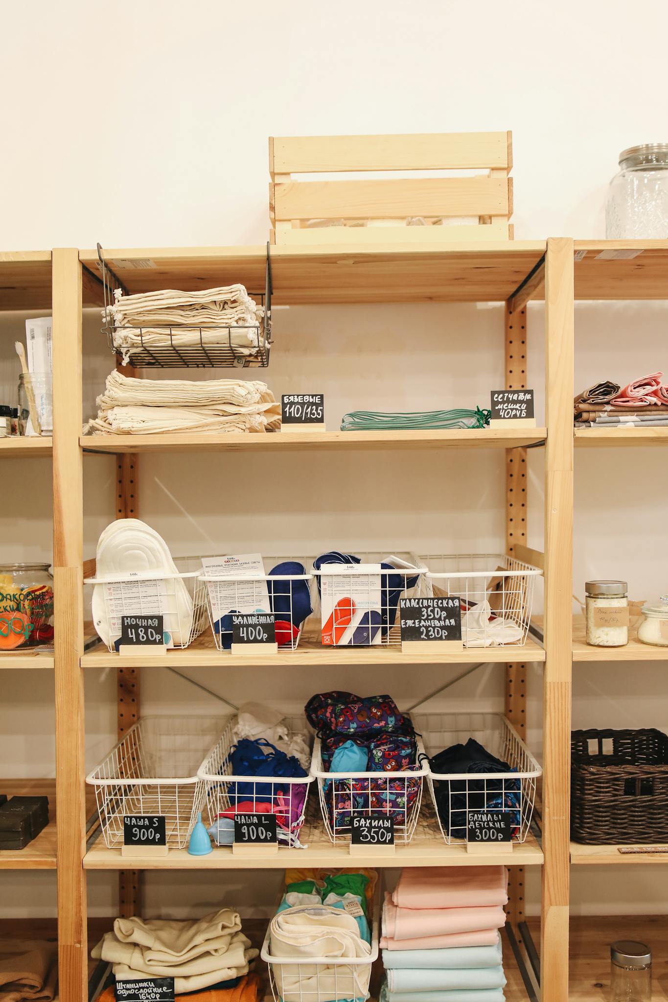 A variety of eco-friendly textiles displayed neatly on wooden shelves in a store.
