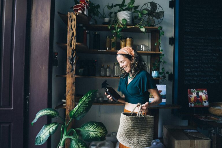 Smiling woman shopping for eco-friendly products in an indoor plant-filled store.